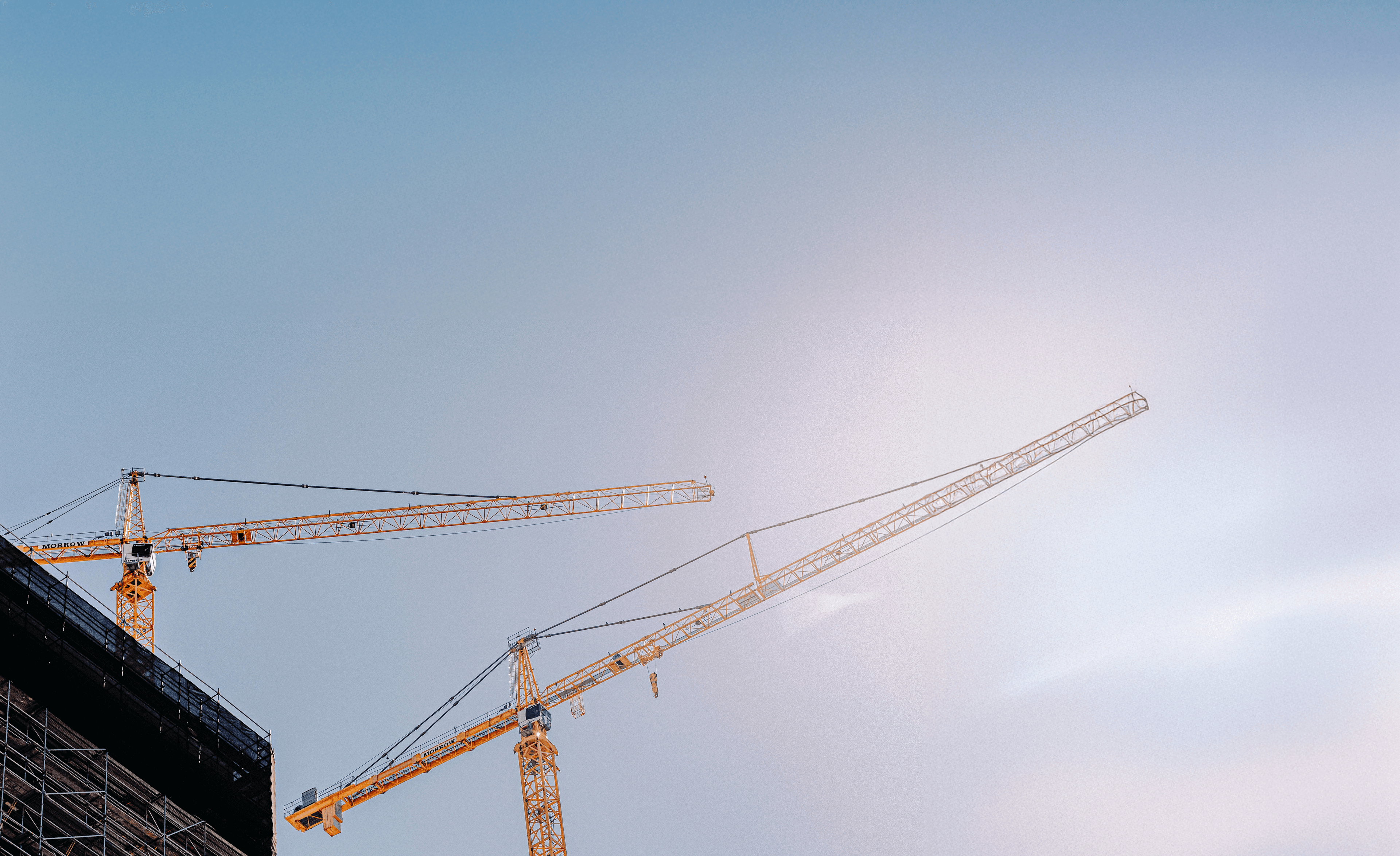 Mehrere Turmkrane vor blauem Himmel - Symbol für professionelle Kranprüfung und Arbeitssicherheit